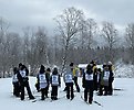 Fjärdklassare står i en ring och lyssnar på ledare.